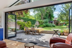 A modern patio with a glass door leading to a lush garden. - 5 Bed in Canterbury (oc-ct043) (Canterbury)
