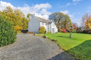 A white building with a gravel driveway leading to a grassy area. - 4 Bed in Staveley (oc-s33928) (Staveley)