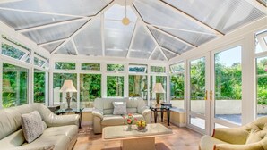 A conservatory with a glass ceiling, beige sofas, a coffee table, and a view of greenery outside. - 3 Bed in Mevagissey (oc-windru) (Mevagissey)