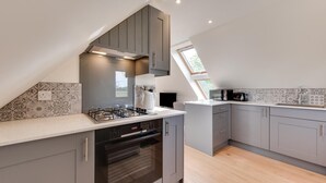 A modern kitchen with a gas stove, oven, and microwave. It features grey cabinetry, a white countertop, and a skylight. - 1 Bed in Booton (oc-2266) (Cawston)