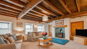 A cozy living room with a sofa, a coffee table, and a fireplace. - 3 Bed in Askrigg (oc-ds1049) (Askrigg)