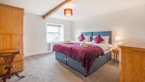 A bedroom with a bed, a window, a wooden wardrobe, and a bedside table. - 3 Bed in Askrigg (oc-ds1049) (Askrigg)