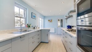 Una cocina moderna con una isla grande, electrodomésticos integrados y mucho espacio en la encimera.