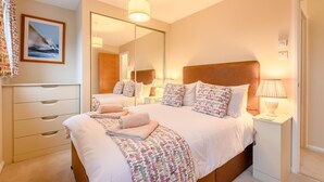 A well-lit bedroom with a large bed, bedside tables, a mirror, and a dresser. - 3 Bed in Christchurch (oc-r27894) (Christchurch)