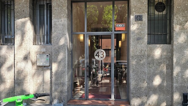 A building entrance with a glass door, numbered 43, and a sign reading "VENDESI". - Three-room In Tortona District (Milano)