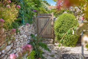 A rustic wooden gate in a garden with stone walls and lush greenery. - 2 Bed in Worth Matravers (oc-q33640) (Worth Matravers)