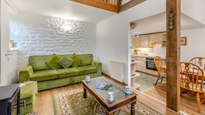 A cozy living room with a green sofa, a coffee table, and a view into the kitchen. - 3 Bed in Barden (oc-s33752) (Barden)