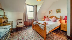 A bedroom with a wooden bed, a chair, a dresser, a window, and a ceiling light. - 5 Bed in Shiskine (oc-b33664) (Shiskine)