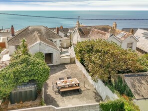 Il s’agit d’une propriété résidentielle dotée d’un patio, offrant une vue sur la mer, et se caractérisant par un bâtiment blanc avec une cheminée.