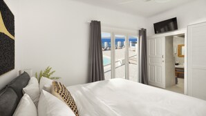 Ein Hotelzimmer mit Bett, Pflanze und Blick auf Strand und Pool.