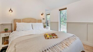A bedroom with a bed, bedside tables, a nightstand, a window, and a view of the outdoors. - 1 Bed in Littlebeck (oc-m33953) (Littlebeck)