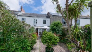 A white two-story house with a garden pathway leading to a covered patio area. - 2 Bed in Mousehole (oc-threeb) (Mousehole)
