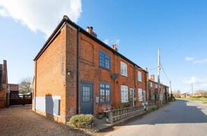 A two-story brick house with a front garden, a driveway, and a clear sky. - 2 Bed in Aldborough (oc-2257) (Aldborough)