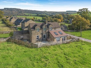 A stone house with a sloped roof and a fenced yard. - 3 Bed in Marske (oc-o33522) (Marske)