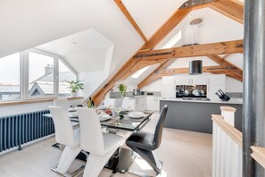 A modern loft apartment with a dining area, kitchen, and a view of the city. - 4 Bed in Saundersfoot (oc-pw9262) (Saundersfoot)