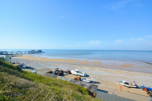 A coastal beach with boats, a pier, and a grassy area. - 3 Bed in Cromer (oc-2254) (Cromer)
