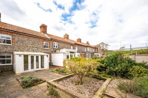 A row of terraced houses with a garden area in the foreground. - 3 Bed in Cromer (oc-2254) (Cromer)
