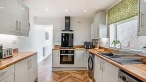 Una cocina moderna con una isla central, horno empotrado y lavavajillas.