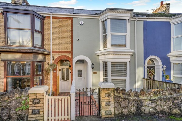 A row of terraced houses with bay windows, a stone wall, and a gate. - 3 Bed in Mumbles (oc-t34004) (The Mumbles)
