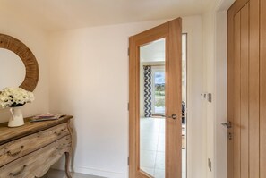 A room with a wooden wardrobe, a mirror, and a door leading to an outdoor area.
