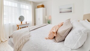 Ein Schlafzimmer mit Bett, Nachttisch, Kleiderschrank und einem Bild an der Wand.