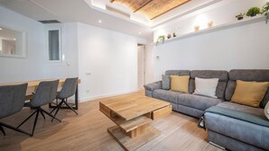 A modern living room with a sofa, coffee table, and chairs. - Modern 2 bedroom apartment in Carrer Balmes (Barcelona)