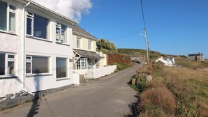 A white two-story house with a porch and a small fence. - 2 Bed in Porthleven (oc-lampho) (Porthleven)