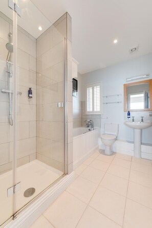 Une salle de bain moderne avec une douche à parois de verre, une baignoire, des toilettes et un lavabo.