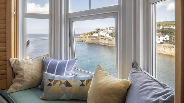 A window seat with cushions, overlooking a coastal town and sea. - 3 Bed in Porthleven (oc-12bayv) (Porthleven)