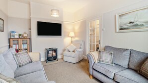 Una sala de estar acogedora con chimenea, televisión y un espacio de descanso cómodo.