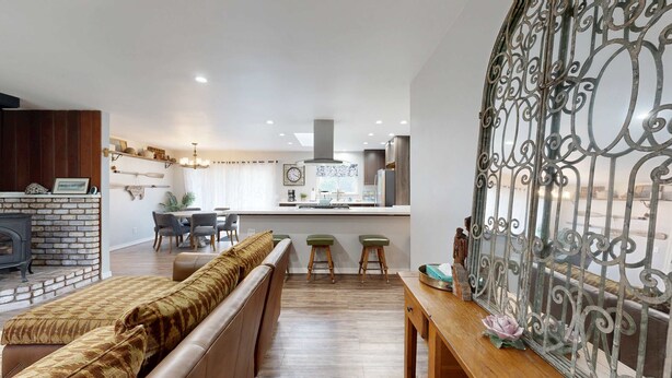 Una sala de estar moderna con chimenea, comedor y cocina con isla central.