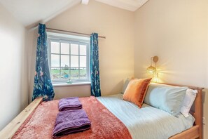 A bedroom with a bed, a window with curtains, a bedside lamp, and a view of the outdoors. - 3 Bed in Fulbeck (oc-v33643) (Fulbeck)