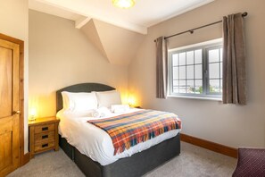 A bedroom with a bed, bedside tables, a window with curtains, and a view of the outside. - 3 Bed in Fulbeck (oc-v33643) (Fulbeck)