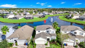 A residential area with houses, a canal, and a red marker. - Poolside 5BR Escape with Pool Table & Parking (Kissimmee)