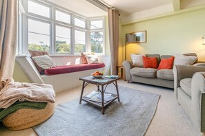 A cozy living room with a sofa, a table, and a window seat. - 2 Bed in Helford (oc-hcview) (Helford)