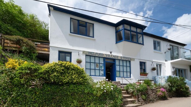 A two-story building with a sign reading "Helford Village Stores" at the entrance. - 2 Bed in Helford (oc-hcview) (Helford)