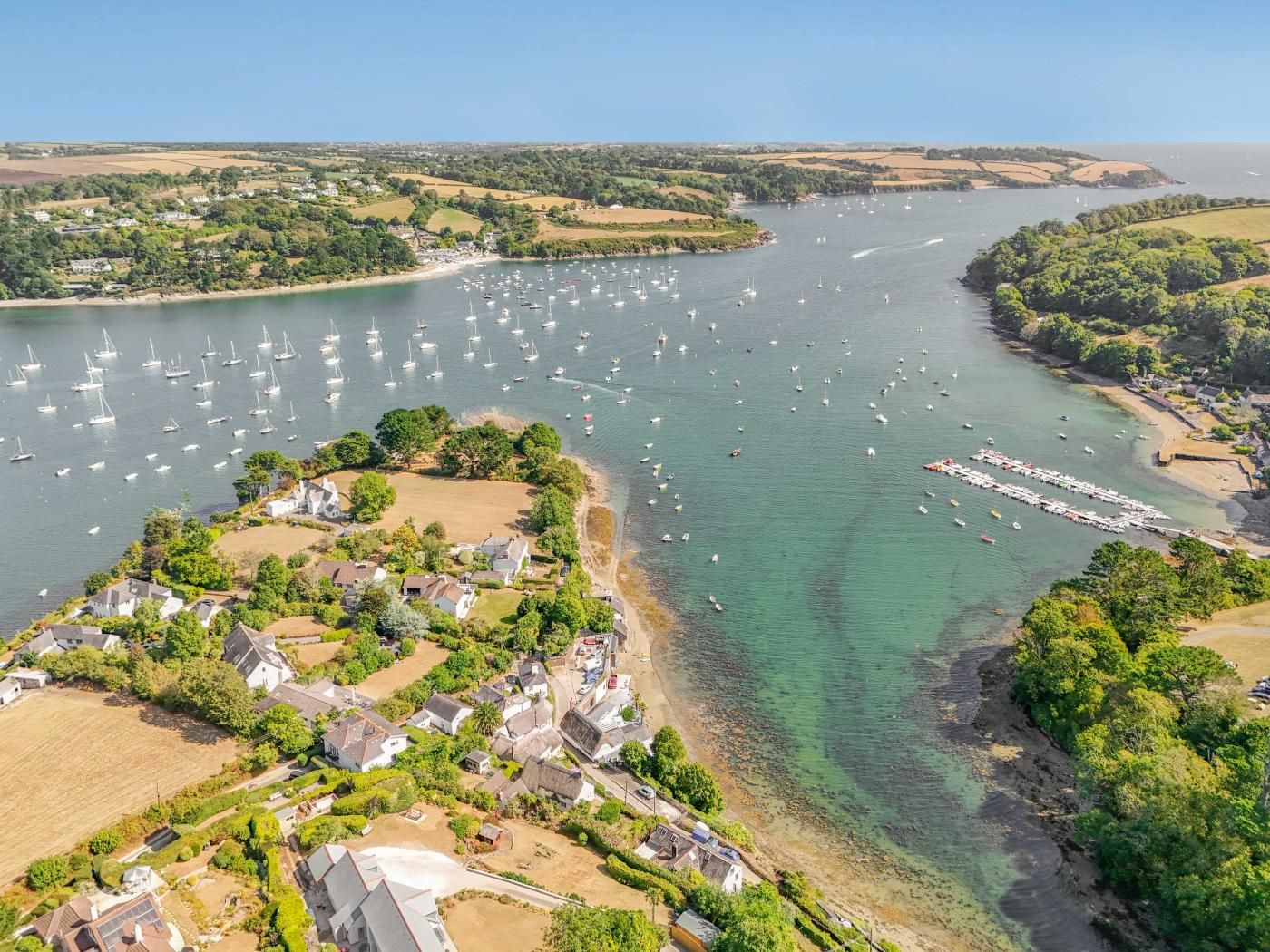 A coastal village with houses, a marina, and boats.