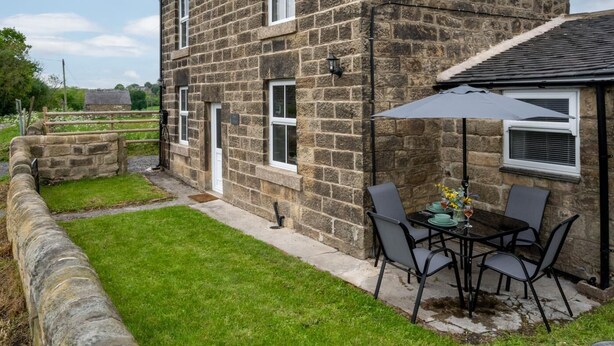 A stone house with a small patio and a table with chairs. - 2 Bed in Matlock (oc-dcbeau) (England)