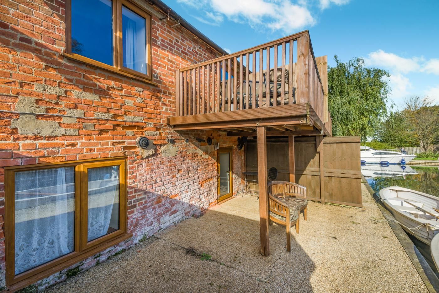 A brick building with a wooden deck and a boat dock.