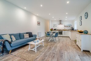 Ein modernes Wohnzimmer mit einer Couch, einem Couchtisch und einem Essbereich.