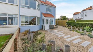 A two-story house with a garden featuring a gravel pathway and various plants. - 4 Bed in Cromer (oc-b34005) (Cromer)