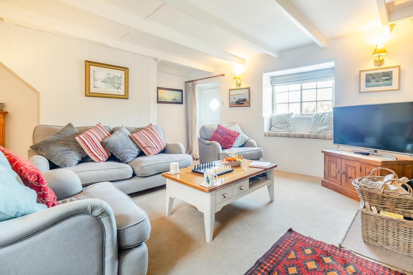 A cozy living room with a grey sofa, a wooden coffee table, and a television.