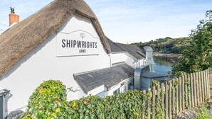 A white building with a thatched roof labeled "SHIPWRIGHTS ARMS". - 2 Bed in Helford (oc-hcpopi) (Helford)
