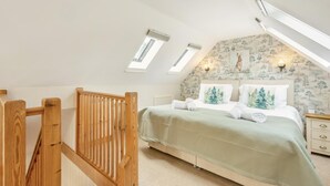 A bedroom with a sloped ceiling, skylights, a bed with a green bedspread, and a wall with a tree pattern. - 1 Bed in Snape (oc-fcf) (Snape)