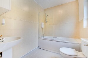 Une salle de bain avec une baignoire, des toilettes et un lavabo.