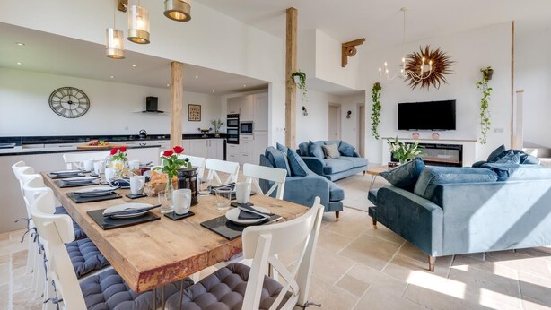 A modern living space with a dining area, a sofa, and a TV. - 5 Bed in Briston (oc-2305) (Briston)