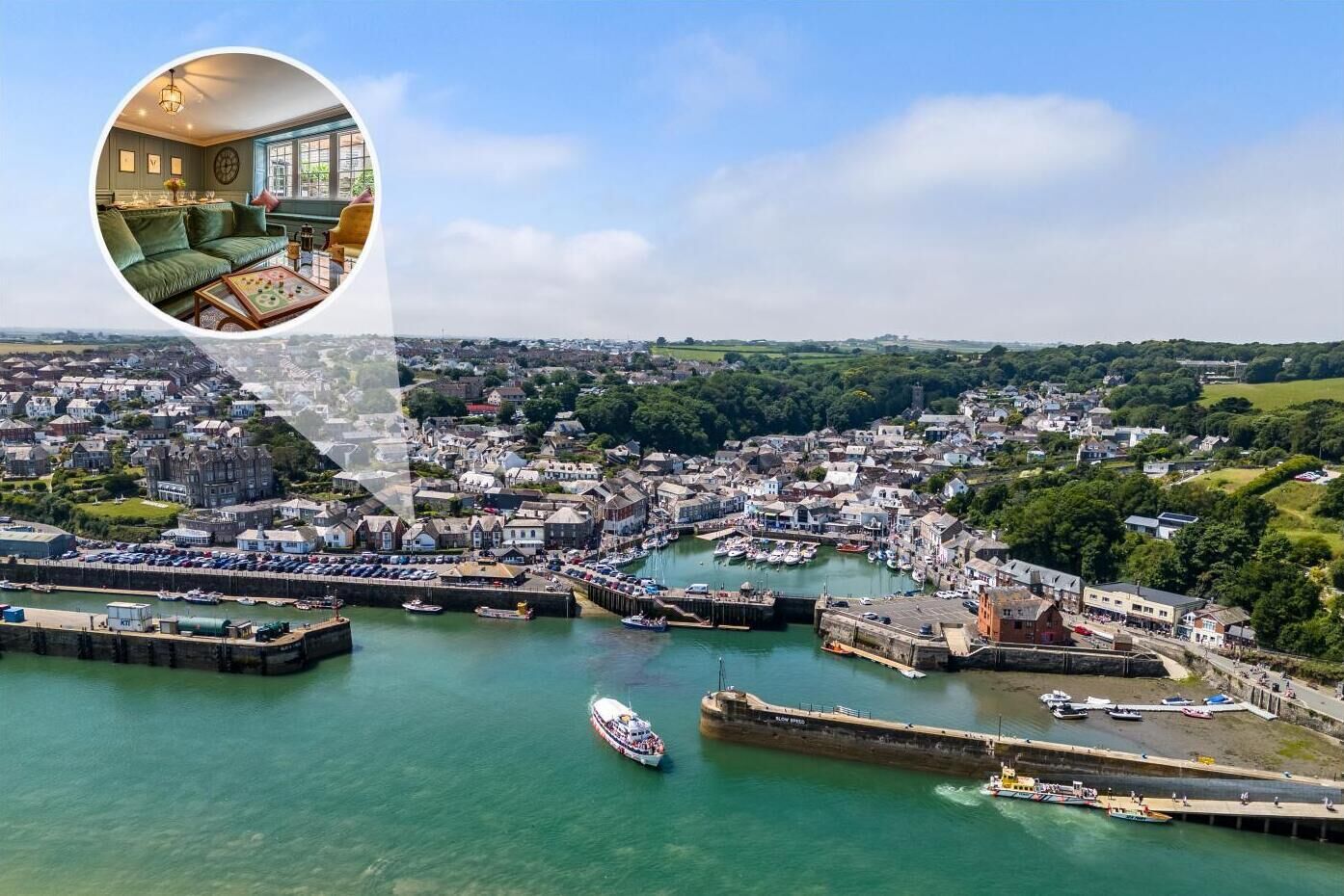 A coastal town with a marina, historic buildings, and a view of the sea.
