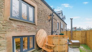 A stone building with large windows and a wooden outdoor seating area. - 4 Bed in Peterchurch (oc-s34019) (Peterchurch)