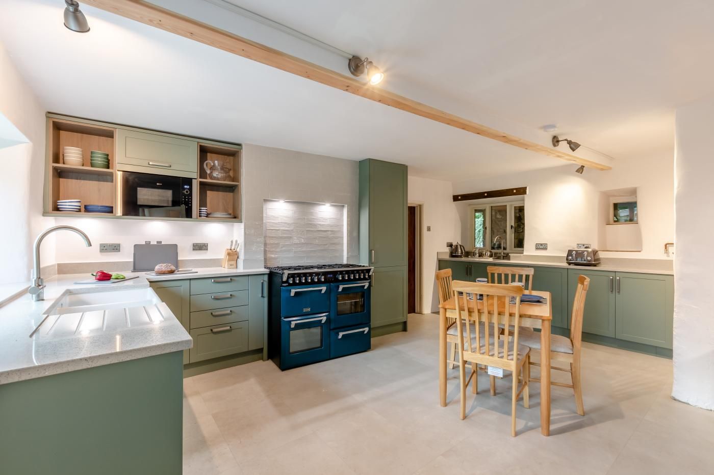 A modern kitchen with a dining area, featuring a built-in stove, cabinets, and a dining table with chairs.