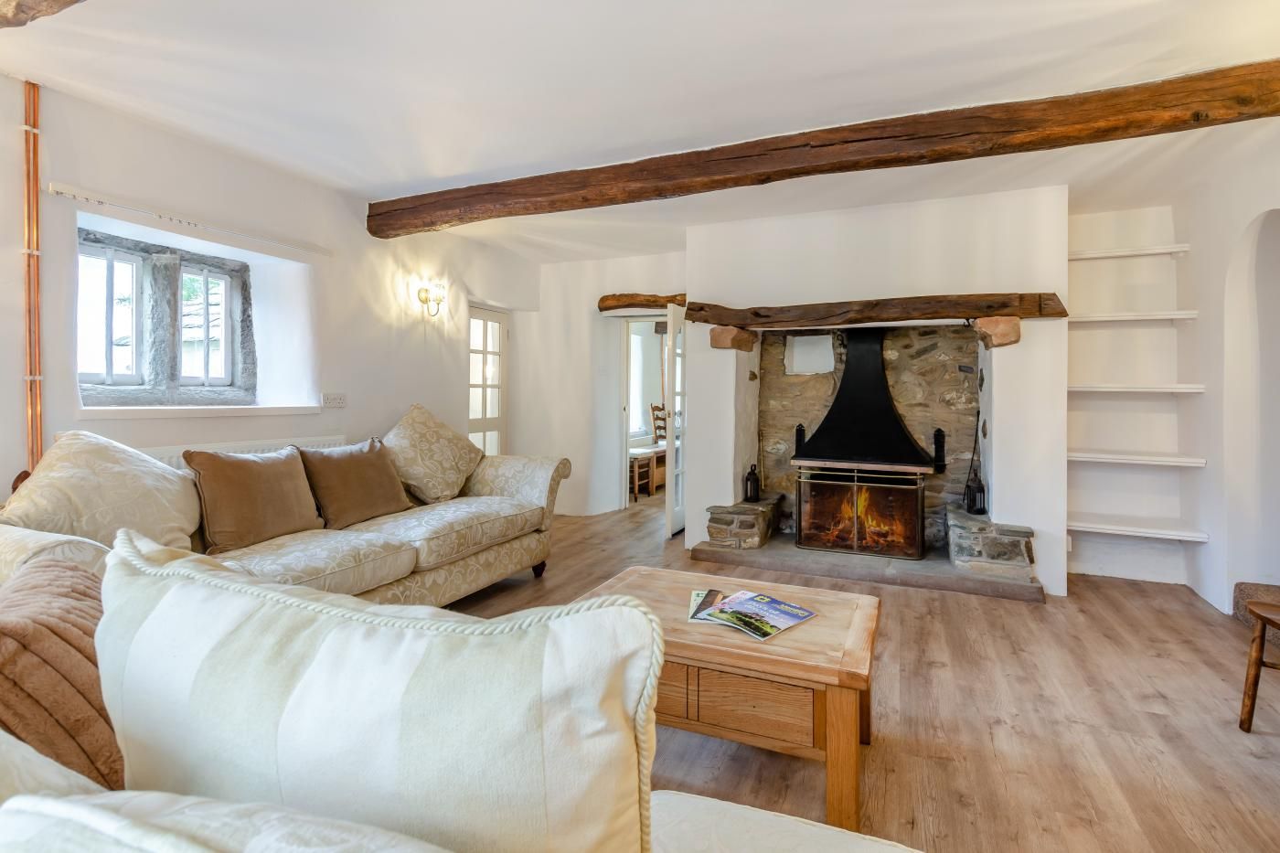 A cozy living room with a fireplace, a sofa, and a coffee table.